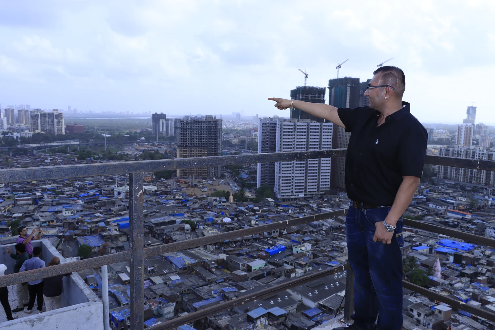 Dr. Anand Modi pointing across Mumbai's high-rise redevelopment landscape.