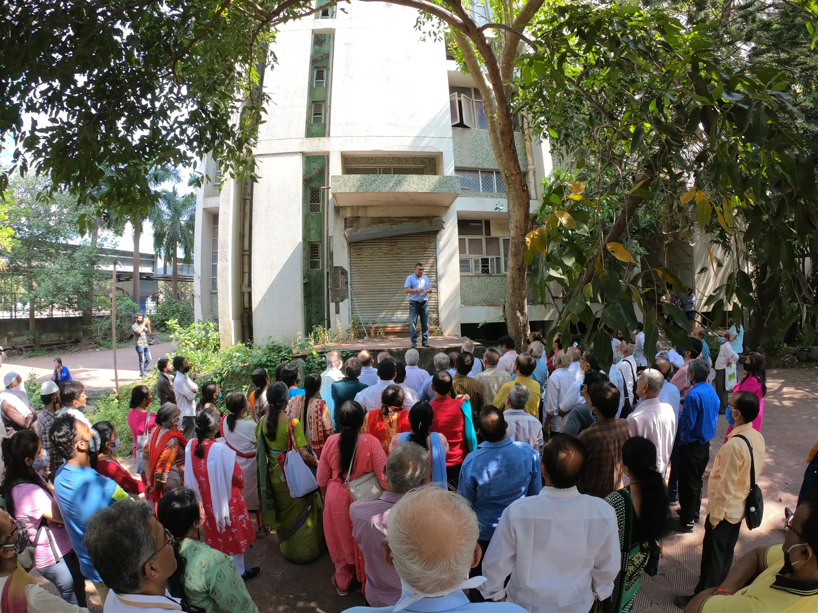 Dr. Anand Modi addressing residents during an outdoor briefing.