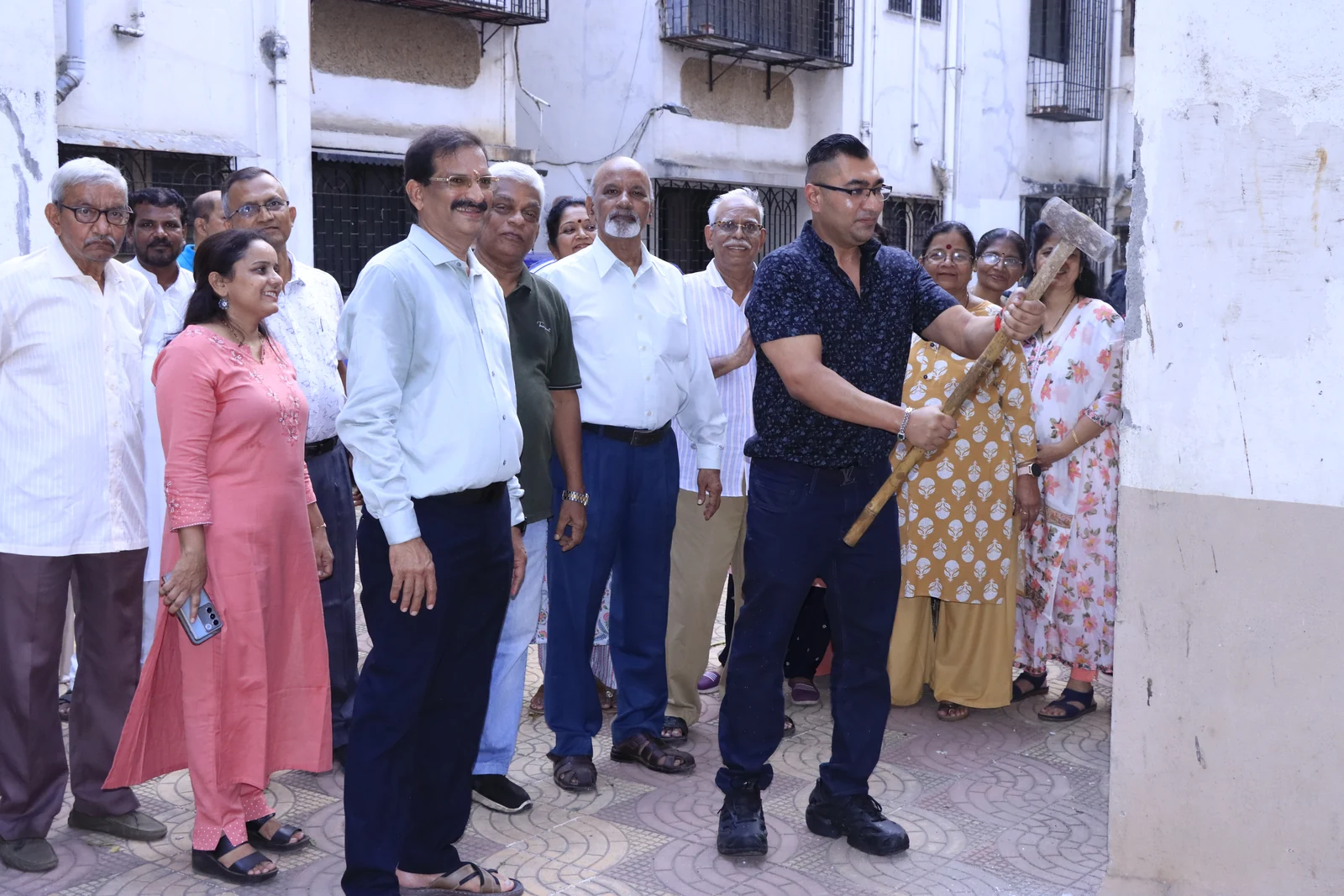 A resident explains a concern directly to Dr. Anand Modi and the surrounding group.